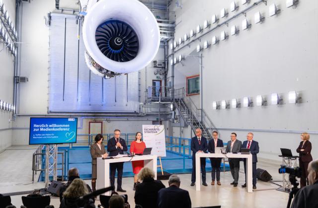 01 April 2026, th, Arnstadt: Representatives from the state government, the business community, and labour unions stand with Mario Voigt, Minister-President of Thuringia (2nd L), at a press conference marking the signing of a skilled workforce strategy in front of a Trent 900 engine in the test tower of N3 Engine Overhaul Services GmbH. The event follows a meeting of the Pact for Growth and Jobs. Photo: Michael Reichel/dpa
