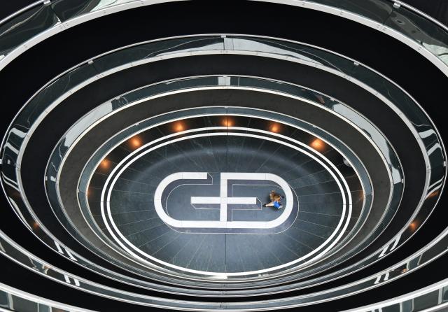 FILED - 17 April 2018, Bavaria, Munich: A woman walks across the Giesecke & Devrient (G+D) logo embedded in the floor at the company's headquarters. Photo: Peter Kneffel/dpa