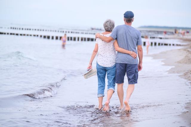 FILED - 20 August 2022, Mecklenburg-Vorpommern, Rostock: A retired couple walks on the beach. Photo: Annette Riedl/dpa