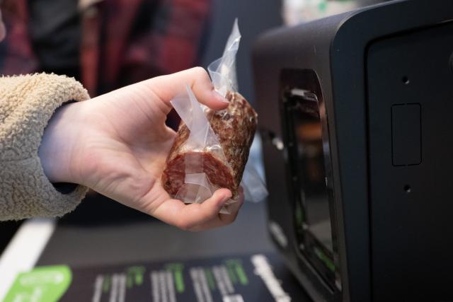 02 April 2026, Saxony, Kurort Oybin: A customer scans a salami at a self-checkout register to mark the grand opening of a "Smart Store". Photo: Sebastian Kahnert/dpa