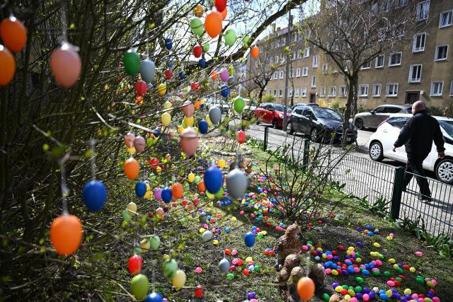 02 April 2026, Berlin: A man walks past a front garden decorated with colorful eggs in the Charlottenburg district of Berlin. Photo: Elisa Schu/dpa