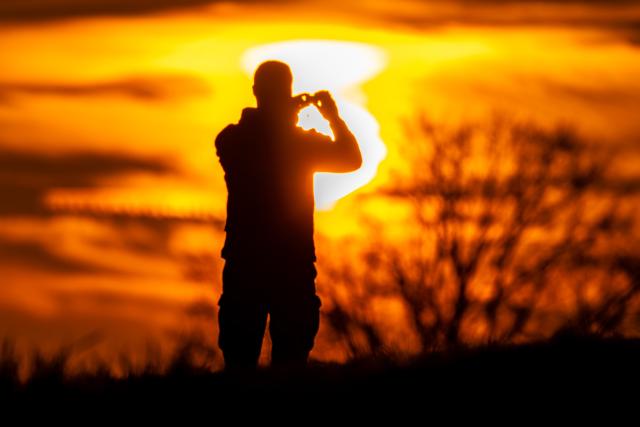 02 April 2026, Brandenburg, Leuthen: A person takes a photo of the sunset in Leuthon. Photo: Frank Hammerschmidt/dpa