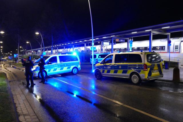 02 April 2026, North Rhine-Westphalia, Siegburg: Policemen and vehicles arrive at Siegburg station. According to the federal police, a man threatened to carry out an attack on an ICE train in North Rhine-Westphalia and slightly injured several people. So-called softair firecrackers exploded and the man was arrested in Siegburg, a spokeswoman told the German Press Agency. Photo: Marius Fuhrmann/dpa