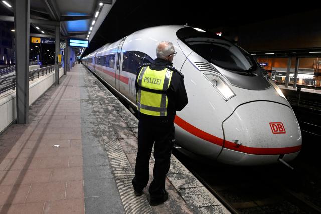 03 April 2026, North Rhine-Westphalia, Siegburg: A police officer stands on a platform at Siegburg Station, where a Deutsche Bahn ICE train is parked. According to the Federal Police, a man threatened to carry out an attack on an ICE train in North Rhine-Westphalia and slightly injured several people. Photo: Roberto Pfeil/dpa
