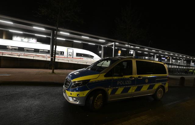 03 April 2026, North Rhine-Westphalia, Siegburg: A police vehicle is parked in front of a platform at Siegburg Station, where a Deutsche Bahn ICE train is stopped. According to the Federal Police, a man threatened to carry out an attack on an ICE train in North Rhine-Westphalia and slightly injured several people. Photo: Roberto Pfeil/dpa