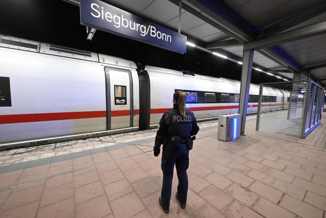 03 April 2026, North Rhine-Westphalia, Siegburg: A policewoman stands on a platform at Siegburg Station, where a Deutsche Bahn ICE train is parked. According to the Federal Police, a man threatened to carry out an attack on an ICE train in North Rhine-Westphalia and slightly injured several people. Photo: Roberto Pfeil/dpa