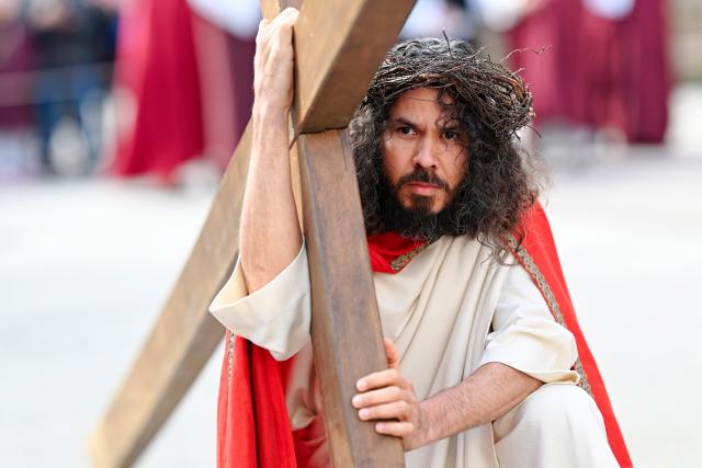 03 April 2026, Hesse, Bensheim: A parishioner portraying Jesus Christ reenacts the Stations of the Cross during a Good Friday procession. The association "Bensheim Italian Families and German Friends" presented the story from Jesus' arrest to his crucifixion in a procession lasting about an hour and a half, with participants wearing historical costumes. Photo: Uwe Anspach/dpa