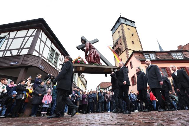 03 April 2026, Bavaria, Lohr am Main: Members of various craft guilds march through the city in a Good Friday procession carrying figures depicting religious scenes. Photo: Karl-Josef Hildenbrand/dpa