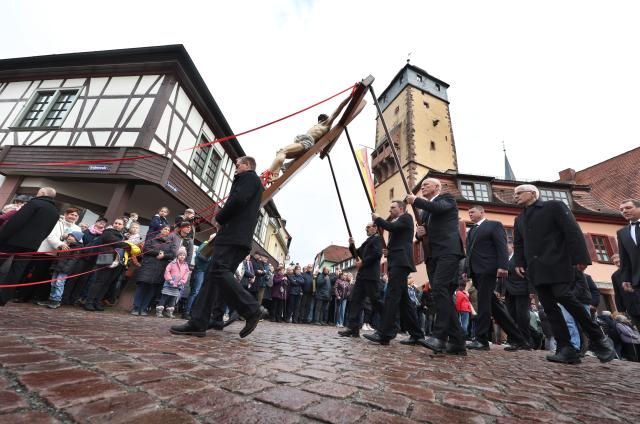 03 April 2026, Bavaria, Lohr am Main: Members of various craft guilds march through the city in a Good Friday procession carrying figures depicting religious scenes. Photo: Karl-Josef Hildenbrand/dpa