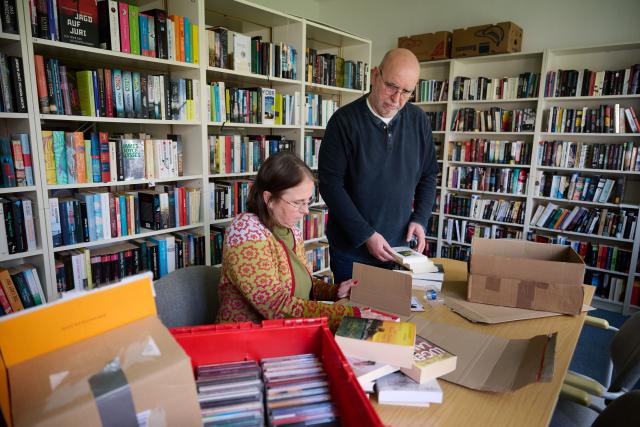 PRODUCTION - 30 March 2026, North Rhine-Westphalia, Dortmund: Board members Monika Pfeifer-Luetkemeyer and Bernd Neumicke are packing book shipments in the library of their Art and Literature Association for Prisoners (KLVG). The KLVG delivers books, DVDs, and CDs to prisons via interlibrary loan and the mail. Photo: Bernd Thissen/dpa