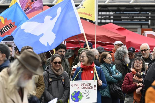 04 April 2026, North Rhine-Westphalia, Duisburg: Participants stand at the starting line of the traditional Rhine-Ruhr Easter March, holding a flag featuring a dove of peace, under the slogan "Capable of peace, not war". Photo: Roberto Pfeil/dpa