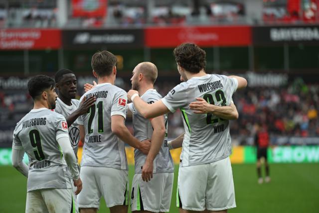 04 April 2026, North Rhine-Westphalia, Leverkusen: Wolfsburg's Jonas Wind (R) celebrates scoring his side's first goal with teammates during the German Bundesliga soccer match between Bayer Leverkusen and VfL Wolfsburg at BayArena. Photo: Fabian Strauch/dpa - WICHTIGER HINWEIS: Gemäß den Vorgaben der DFL Deutsche Fußball Liga bzw. des DFB Deutscher Fußball-Bund ist es untersagt, in dem Stadion und/oder vom Spiel angefertigte Fotoaufnahmen in Form von Sequenzbildern und/oder videoähnlichen Fotostrecken zu verwerten bzw. verwerten zu lassen.