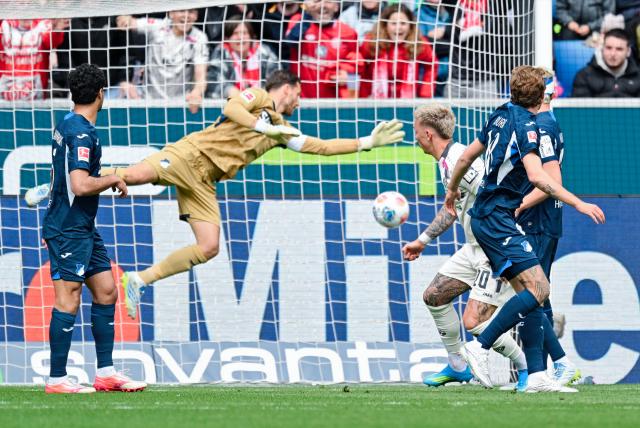 04 April 2026, Baden-Württemberg, Sinsheim: Mainz' Phillip Tietz scores his side's first goal past Hoffenheim goalkeeper Oliver Baumann during the German Bundesliga soccer match between TSG 1899 Hoffenheim and FSV Mainz 05 at the PreZero Arena. Photo: Uwe Anspach/dpa - IMPORTANT NOTICE: DFL and DFB regulations prohibit any use of photographs as image sequences and/or quasi-video.