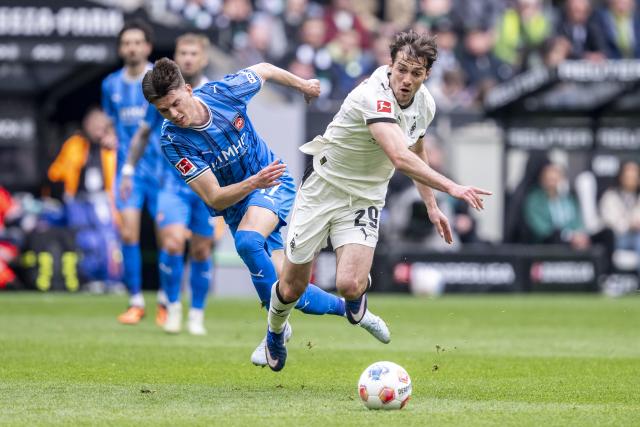 04 April 2026, North Rhine-Westphalia, Moenchengladbach: Heidenheim's Mathias Honsak (L) and Gladbach's Joe Scally in action during the German Bundesliga soccer match between Borussia Moenchengladbach and 1. FC Heidenheim at Borussia-Park Stadium. Photo: David Inderlied/dpa - IMPORTANT NOTICE: DFL and DFB regulations prohibit any use of photographs as image sequences and/or quasi-video.