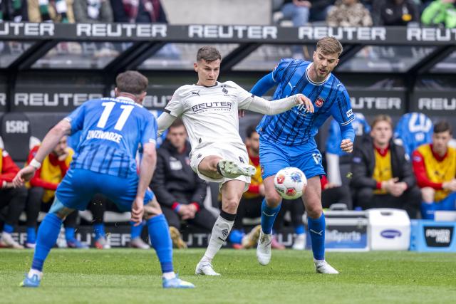 04 April 2026, North Rhine-Westphalia, Moenchengladbach: Heidenheim's Budu Siwsiwadse and Mathias Honsak battle for the ball with Gladbach's Yannik Engelhardt during the German Bundesliga soccer match between Borussia Moenchengladbach and 1. FC Heidenheim at Borussia-Park Stadium. Photo: David Inderlied/dpa - IMPORTANT NOTICE: DFL and DFB regulations prohibit any use of photographs as image sequences and/or quasi-video.