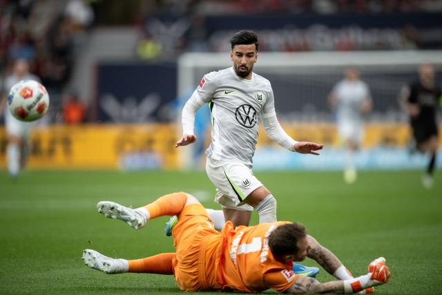 04 April 2026, North Rhine-Westphalia, Leverkusen: Leverkusen's goalkeeper Mark Flekken  and Wolfsburg's Mohamed Amoura in action during the German Bundesliga soccer match between Bayer Leverkusen and VfL Wolfsburg at BayArena. Photo: Fabian Strauch/dpa - IMPORTANT NOTICE: DFL and DFB regulations prohibit any use of photographs as image sequences and/or quasi-video.