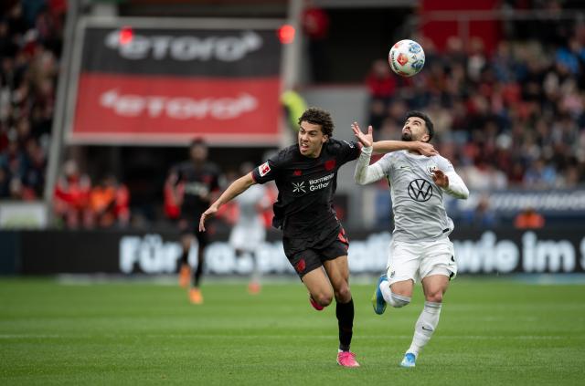 04 April 2026, North Rhine-Westphalia, Leverkusen: Leverkusen's Montrell Culbreath (L) and Wolfsburg's Mohamed Amoura battl for the ball during the German Bundesliga soccer match between Bayer Leverkusen and VfL Wolfsburg at BayArena. Photo: Fabian Strauch/dpa - IMPORTANT NOTICE: DFL and DFB regulations prohibit any use of photographs as image sequences and/or quasi-video.