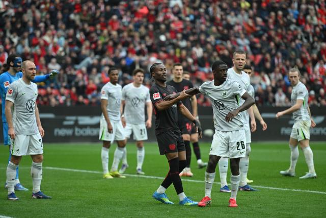 04 April 2026, North Rhine-Westphalia, Leverkusen: Leverkusen's Nathan Tella and Wolfsburg's Kumbedi in action during the German Bundesliga soccer match between Bayer Leverkusen and VfL Wolfsburg at BayArena. Photo: Fabian Strauch/dpa - IMPORTANT NOTICE: DFL and DFB regulations prohibit any use of photographs as image sequences and/or quasi-video.