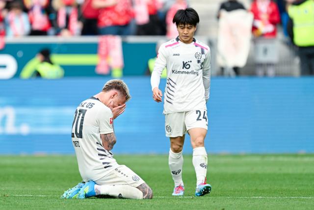 04 April 2026, Baden-Württemberg, Sinsheim: Mainz' Phillip Tietz kneels next to Sota Kawasaki after the German Bundesliga soccer match between TSG 1899 Hoffenheim and FSV Mainz 05 at the PreZero Arena. Photo: Uwe Anspach/dpa - IMPORTANT NOTICE: DFL and DFB regulations prohibit any use of photographs as image sequences and/or quasi-video.