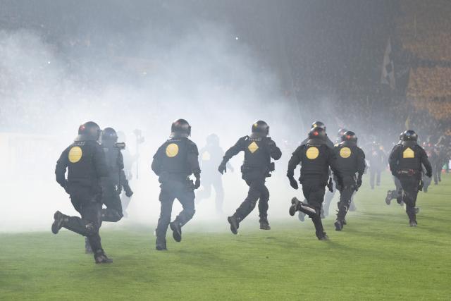 04 April 2026, Saxony, Dresden: Police officers run onto the pitchduring a stoppage at the German 2nd Bundesliga soccer match between Dynamo Dresden and Hertha BSC, at the Rudolf-Harbig-Stadium. Photo: Sebastian Kahnert/dpa - IMPORTANT NOTICE: DFL and DFB regulations prohibit any use of photographs as image sequences and/or quasi-video.