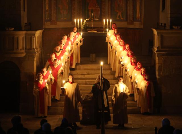 05 April 2026, Saxony-Anhalt, Gernrode: Believers hold the Easter light at the collegiate church of St. Cyriacus. The Holy Easter Play takes place at the collegiate church in Gernrode since 1989. Photo: Matthias Bein/dpa