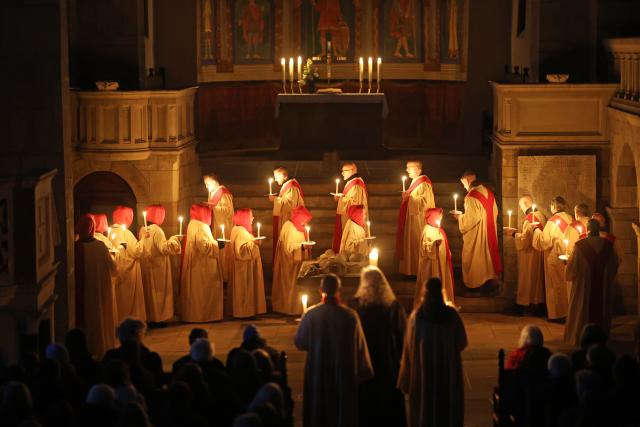 05 April 2026, Saxony-Anhalt, Gernrode: Believers hold the Easter light at the collegiate church of St. Cyriacus. The Holy Easter Play takes place at the collegiate church in Gernrode since 1989. Photo: Matthias Bein/dpa