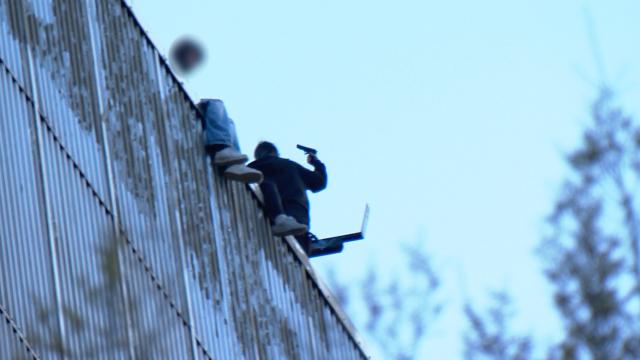 05 April 2026, North Rhine-Westphalia, Dortmund: People, one of whom is holding an object resembling a firearm, are seen on the Kronenturm in Dortmund. Three young adults-two women and one man-climbed the 65-metre-high tower, triggering a police special forces response. According to reports, they threw rocks and a ladder from the tower. Photo: Wickern, Wüllner/News 4 Video-Line TV /dpa - ATTENTION: individual(s) has/have been pixelated for legal reasons