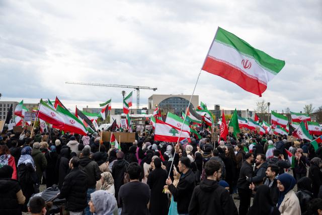 05 April 2026, Berlin: People take part in a demonstration under the slogan 'Stop US-Israeli Aggression!' while holding Iranian flags, protesting against US and Israeli actions in the Middle East. Photo: Christophe Gateau/dpa