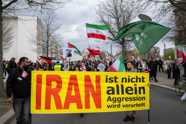 05 April 2026, Berlin: People take part in a demonstration under the slogan 'Stop US-Israeli Aggression!' while holding Iranian flags, protesting against US and Israeli actions in the Middle East. Photo: Christophe Gateau/dpa
