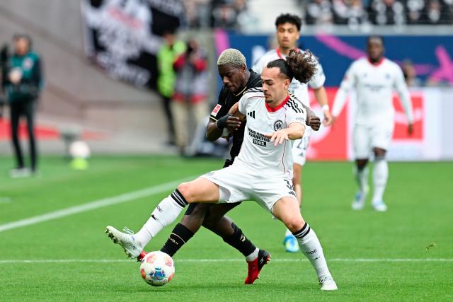 05 April 2026, Hesse, Frankfurt_Main: Cologne's Ragnar Ache (L) and Eintracht Frankfurt's Arthur Theate battle for the ball during the German Bundesliga soccer match between Eintracht Frankfurt and 1. FC Cologne at Deutsche Bank Park Photo: Uwe Anspach/dpa - WICHTIGER HINWEIS: Gemäß den Vorgaben der DFL Deutsche Fußball Liga bzw. des DFB Deutscher Fußball-Bund ist es untersagt, in dem Stadion und/oder vom Spiel angefertigte Fotoaufnahmen in Form von Sequenzbildern und/oder videoähnlichen Fotostrecken zu verwerten bzw. verwerten zu lassen.