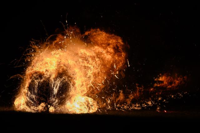 05 April 2026, Hesse, Günsterode: Flaming, straw-filled wagon wheels roll down Kehrenbach Hill during the traditional Burning Wheels Run on Easter Sunday. The custom is intended to symbolically drive away winter. Photo: Swen Pförtner/dpa