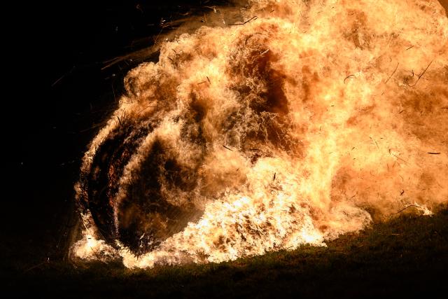 05 April 2026, Hesse, Günsterode: Flaming, straw-filled wagon wheels roll down Kehrenbach Hill during the traditional Burning Wheels Run on Easter Sunday. The custom is intended to symbolically drive away winter. Photo: Swen Pförtner/dpa