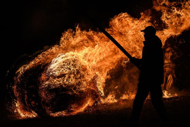 05 April 2026, Hesse, Günsterode: Flaming, straw-filled wagon wheels roll down Kehrenbach Hill during the traditional Burning Wheels Run on Easter Sunday. The custom is intended to symbolically drive away winter. Photo: Swen Pförtner/dpa