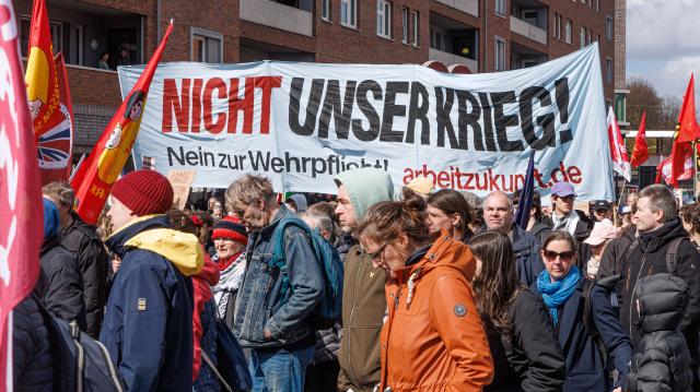 06 April 2026, Hamburg: People hold a large banner during the Easter march under the motto "Not our war!". The annual Easter march was organized by the Hamburg Forum for International Understanding and Global Disarmament. Photo: Markus Scholz/dpa