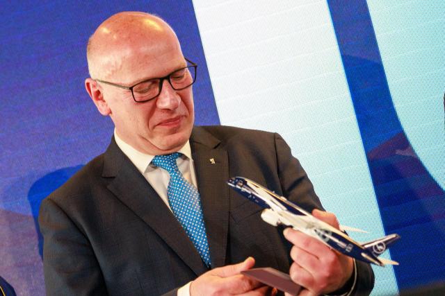 06 April 2026, Brandenburg, Schoenefeld: Kai Wegner, Governing Mayor of Berlin, holds a model of a Lufthansa passenger aircraft during celebrations marking the 100th anniversary of the airline's first flight at Berlin Brandenburg Airport (BER). Photo: Carsten Koall/dpa