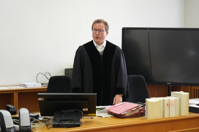 07 April 2026, Hamburg: Judge Goettsche (C) presides over the trial at the district court regarding the blockade of Hamburg Airport in July 2023. The defendant is accused of entering the grounds of Hamburg Airport without authorization in July 2023, together with co-defendants who are being prosecuted separately, and of gluing one of his hands to the runway using superglue. Photo: Marcus Brandt/dpa