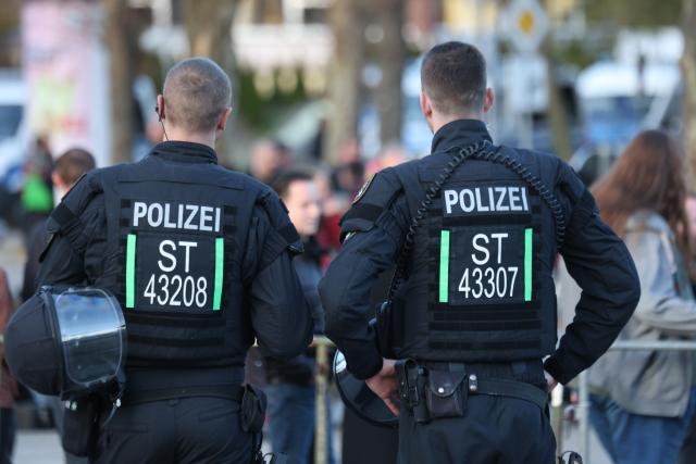 08 April 2026, Saxony-Anhalt, Salzwedel: Police officers stand in front of the Kulturhaus in Salzwedel, providing security for an AfD campaign event. Photo: Matthias Bein/dpa