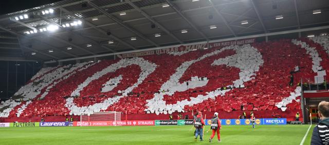 09 April 2026, Rhineland-Palatinate, Mainz: Mainz fans display the club crest with a choreographed display ahead of the UEFA Europa Conference League Quarter-Final first leg soccer match between FSV Mainz 05 and Racing Strasbourg at Mewa Arena. Photo: Torsten Silz/dpa