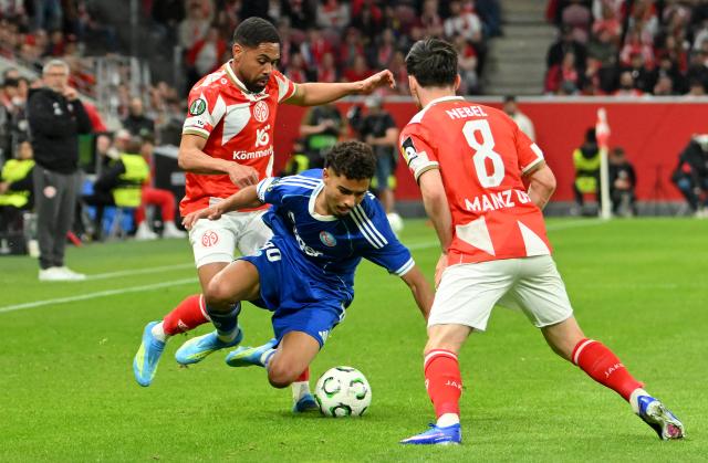09 April 2026, Rhineland-Palatinate, Mainz: Mainz's Phillipp Mwene (L) and Mainz's Paul Nebel (R) battle for the ball Racing Strasbourg's Felix Lemarechal during the UEFA Europa Conference League Quarter-Final first leg soccer match between FSV Mainz 05 and Racing Strasbourg at Mewa Arena. Photo: Torsten Silz/dpa