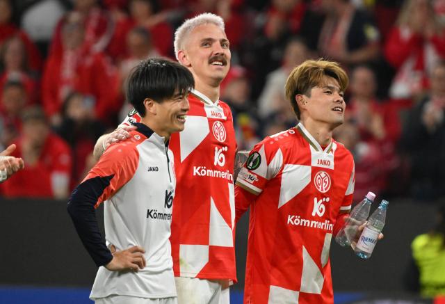 09 April 2026, Rhineland-Palatinate, Mainz: Mainz's Sota Kawasaki and Mainz's Phillip Tietz and Mainz Kaishu Sano celebrate the victory with the fans after the UEFA Europa Conference League Quarter-Final first leg soccer match between FSV Mainz 05 and Racing Strasbourg at Mewa Arena. Photo: Torsten Silz/dpa