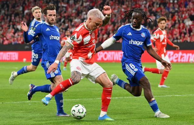 09 April 2026, Rhineland-Palatinate, Mainz: Mainz's Phillip Tietz (C) and Racing Strasbourg's Ismael Doukoure (R) and Ben Chilwell battle for the ball during the UEFA Europa Conference League Quarter-Final first leg soccer match between FSV Mainz 05 and Racing Strasbourg at Mewa Arena. Photo: Torsten Silz/dpa