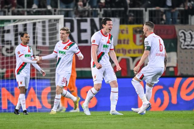 10 April 2026, Bavaria, Augsburg: Augsburg's Michael Gregoritsch (2nd R) celebrates with his teammates their side's second goal of the game during the German Bundesliga soccer match between FC Augsburg and TSG 1899 Hoffenheim at the WWK-Arena. Photo: Harry Langer/dpa - WICHTIGER HINWEIS: Gemäß den Vorgaben der DFL Deutsche Fußball Liga bzw. des DFB Deutscher Fußball-Bund ist es untersagt, in dem Stadion und/oder vom Spiel angefertigte Fotoaufnahmen in Form von Sequenzbildern und/oder videoähnlichen Fotostrecken zu verwerten bzw. verwerten zu lassen.