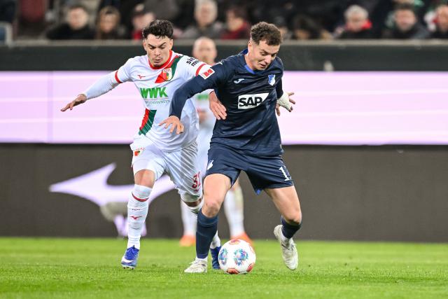 10 April 2026, Bavaria, Augsburg: Augsburg's Fabian Rieder (L) and Hoffenheim's Fisnik Asllani battle for the ball during the German Bundesliga soccer match between FC Augsburg and TSG 1899 Hoffenheim at the WWK-Arena. Photo: Harry Langer/dpa - WICHTIGER HINWEIS: Gemäß den Vorgaben der DFL Deutsche Fußball Liga bzw. des DFB Deutscher Fußball-Bund ist es untersagt, in dem Stadion und/oder vom Spiel angefertigte Fotoaufnahmen in Form von Sequenzbildern und/oder videoähnlichen Fotostrecken zu verwerten bzw. verwerten zu lassen.