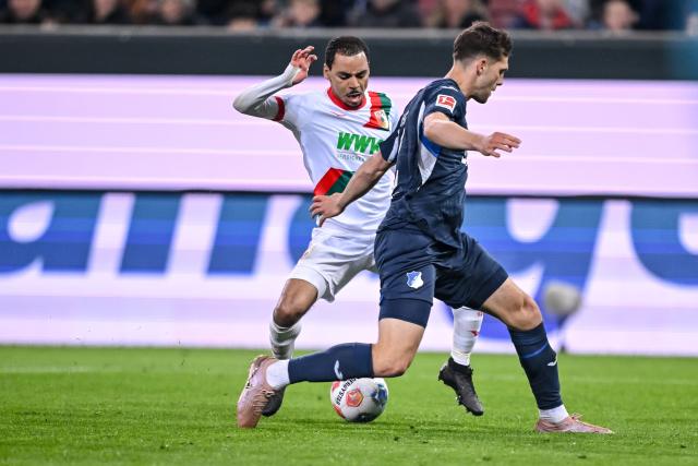 10 April 2026, Bavaria, Augsburg: Augsburg's Alexis Claude-Maurice (L) and Hoffenheim's Robin Hranac battle for the ball during the German Bundesliga soccer match between FC Augsburg and TSG 1899 Hoffenheim at the WWK-Arena. Photo: Harry Langer/dpa - WICHTIGER HINWEIS: Gemäß den Vorgaben der DFL Deutsche Fußball Liga bzw. des DFB Deutscher Fußball-Bund ist es untersagt, in dem Stadion und/oder vom Spiel angefertigte Fotoaufnahmen in Form von Sequenzbildern und/oder videoähnlichen Fotostrecken zu verwerten bzw. verwerten zu lassen.