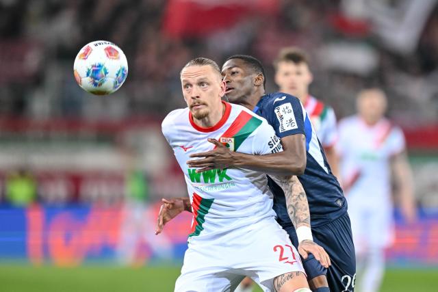 10 April 2026, Bavaria, Augsburg: Augsburg's Marius Wolf (L) and Hoffenheim's Bazoumana Toure battle for the ball during the German Bundesliga soccer match between FC Augsburg and TSG 1899 Hoffenheim at the WWK-Arena. Photo: Harry Langer/dpa - WICHTIGER HINWEIS: Gemäß den Vorgaben der DFL Deutsche Fußball Liga bzw. des DFB Deutscher Fußball-Bund ist es untersagt, in dem Stadion und/oder vom Spiel angefertigte Fotoaufnahmen in Form von Sequenzbildern und/oder videoähnlichen Fotostrecken zu verwerten bzw. verwerten zu lassen.