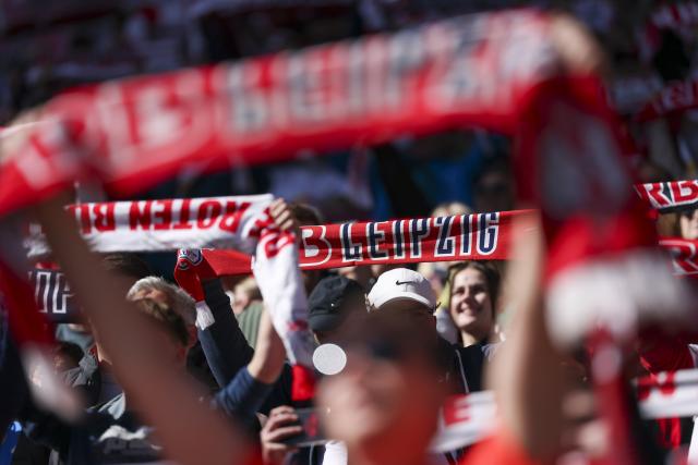 11 April 2026, Saxony, Leipzig: Leipzig fans hold up their scarves in the stands before the start of the German Bundesliga soccer match between RB Leipzig and Borussia Moenchengladbach at the Red Bull Arena. Photo: Jan Woitas/dpa - IMPORTANT NOTE: In accordance with the regulations of the DFL German Football League and the DFB German Football Association, it is prohibited to utilize or have utilized photographs taken in the stadium and/or of the match in the form of sequential images and/or video-like photo series.