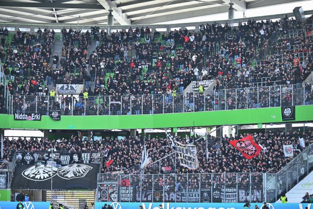 11 April 2026, Lower Saxony, Wolfsburg: Eintracht Frankfurt fans cheer in the visitors' section, waving numerous flags and banners during the German Bundesliga soccer match between VfL Wolfsburg and Eintracht Frankfurt at the Volkswagen Arena. Photo: Swen Pförtner/dpa - IMPORTANT NOTICE: DFL and DFB regulations prohibit any use of photographs as image sequences and/or quasi-video.