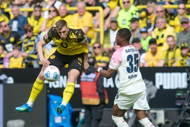 11 April 2026, North Rhine-Westphalia, Dortmund: Borussia Dortmund's Nico Schlotterbeck and Bayer Leverkusen's Christian Kofane battle for the ball during the German Bundesliga soccer match between Borussia Dortmund and Bayer Leverkusen at Signal Iduna Park. Photo: Bernd Thissen/dpa - WICHTIGER HINWEIS: Gemäß den Vorgaben der DFL Deutsche Fußball Liga bzw. des DFB Deutscher Fußball-Bund ist es untersagt, in dem Stadion und/oder vom Spiel angefertigte Fotoaufnahmen in Form von Sequenzbildern und/oder videoähnlichen Fotostrecken zu verwerten bzw. verwerten zu lassen.