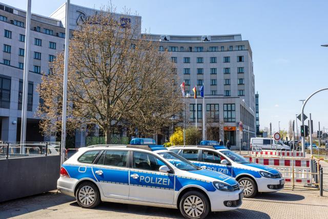 11 April 2026, Brandenburg, Cottbus: Police vehicles are parked in front of the conference hotel, where the AfD's parliamentary group has been holding a closed-door meeting since yesterday. Photo: Frank Hammerschmidt/dpa