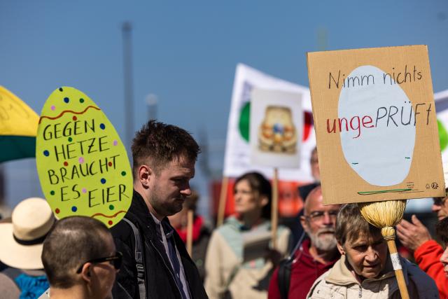 11 April 2026, Brandenburg, Cottbus: 'It takes guts to stand up to hate speech' and 'Don't accept anything at face value' read the signs carried by demonstrators at the main train station. The protest calls for an investigation into and a ban on the AfD, whose parliamentary group in the Bundestag gathered in the city for a three-day closed-door meeting. Photo: Frank Hammerschmidt/dpa